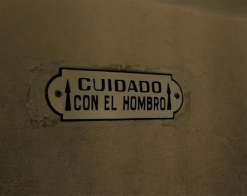 Cartel: "¡Cuidado con el hombro!" en el ascenso al Paraíso del Palacio Barolo.